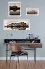 A desk setup with framed pictures on the wall above it. Produktbild-Vorschau