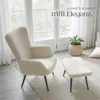 A cream-colored armchair and ottoman are placed on a rug in a well-lit room with large windows. Náhled obrázku produktu