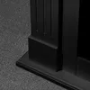 A close-up view of the base of a black wooden fireplace frame, resting on a grey carpet. Anteprima dell’immagine prodotto