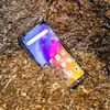 A smartphone submerged in water with pebbles. Podgląd zdjęcia produktu