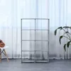 A multi-shelf storage unit is shown in a room with a white curtain in the background. A small ukulele is on a white stool to the left, and a plant is to the right. Produktbild-Vorschau