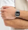 A person's arm wearing a silver digital watch. Produktbild-Vorschau