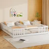 Two white children's beds with guardrails are set up in a room with decorative wall art and a plant on a side table. Náhľad obrázku produktu
