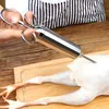 A hand is holding a stainless steel marinade injector over a raw chicken on a wooden cutting board. Voir les images du produit
