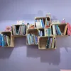 Wooden crates used as shelves on a purple wall, filled with books and small decorative items. Náhled obrázku produktu