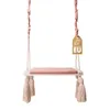 A baby swing with a pink cushioned seat and tassels, hanging against a white background. A 'Made in EU' tag is attached to one of the ropes. Podgląd zdjęcia produktu