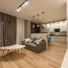 A modern living room and kitchen area with a sofa, coffee table, and kitchen cabinets. Anteprima dell’immagine prodotto