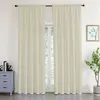 A pair of beige curtains hangs in front of a window, with a small dresser and a plant visible. Produktbild-Vorschau