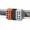 Three terminal blocks of different colors (orange, black, and white) are mounted on a metal rail. Produktbild-Vorschau
