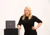 A woman poses next to an HP Spectre x360 laptop. Produktbild-Vorschau