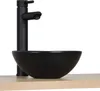 A black ceramic vessel sink with a black faucet mounted on a light wood countertop. Anteprima dell’immagine prodotto