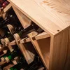 A close-up view of a wooden wine rack holding several dark glass wine bottles. Voir les images du produit