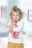 A young girl is holding a baby doll in a nursery-like setting. Náhľad obrázku produktu