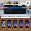 A modern black coffee table with blue LED lighting, shown in a living room setting, with accompanying smartphone app screenshots demonstrating features. Produktbild-Vorschau