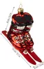 A glass ornament shaped like red ski boots attached to short skis, with dimensions indicated by measurement lines. Voir les images du produit