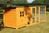 A wooden chicken coop with an attached run, set up on a grassy lawn. Produktbild-Vorschau
