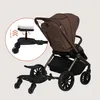 A brown stroller with a black buggy board attached to the back. Náhľad obrázku produktu
