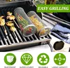 Two stainless steel grill baskets filled with food are placed on a grill, with some grilled food already on skewers to the left. The scene is set outdoors. Produktbild-Vorschau