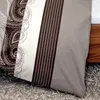 A close-up view of a pillow with a patterned design, resting on a textured rug next to a wooden surface. Produktbild-Vorschau