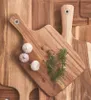 A top-down view of several wooden cutting boards, with garlic and herbs on one of them. Anteprima dell’immagine prodotto
