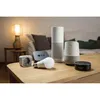 A collection of smart home devices arranged on a wooden table in a living room setting. Anteprima dell’immagine prodotto