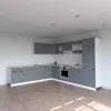 A modern, empty kitchen with gray cabinets and a wooden floor. Podgląd zdjęcia produktu