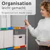 A woman is organizing files on a shelf using colorful labels. Produktbild-Vorschau