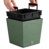 Hands holding a black insert for a green planter. Produktbild-Vorschau