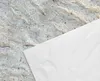 A close-up view of a textured surface, possibly stone or concrete, with a white sheet of material draped over a portion of it. Produktbild-Vorschau