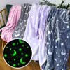 Several folded blankets with moon and star patterns are displayed on a chair. Produktbild-Vorschau