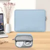 A light blue laptop sleeve and a small pouch containing a white mouse and charging cable are displayed on a wooden desk. Produktbild-Vorschau