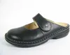 A black leather clog shoe with a strap is shown against a white background. Podgląd zdjęcia produktu