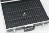 An empty black storage case with multiple compartments, designed for storing small items like tapes or cartridges. The case has silver trim and a handle. Two small, unidentifiable objects are visible inside one of the compartments. Produktbild-Vorschau