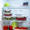 A view inside a refrigerator, showing various food items stored in glass containers on shelves. Anteprima dell’immagine prodotto