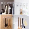 Collage of images showing clear adhesive hooks in various household settings, holding items like keys, bags, utensils, and bath sponges. Produktbild-Vorschau