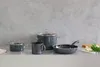 A set of dark gray cookware, including pots and a frying pan, arranged on a white countertop against a textured gray wall. Anteprima dell’immagine prodotto