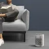 A person is sitting on a couch reading a book, with a small heater on the floor nearby. Anteprima dell’immagine prodotto