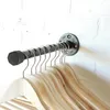 A pipe-style wall-mounted coat rack with wooden hangers attached, mounted on a white brick wall. Podgląd zdjęcia produktu