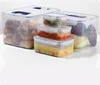A collection of clear plastic food storage containers with blue lids and handles, filled with various food items. Náhľad obrázku produktu