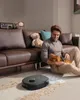 A man is sitting on the floor petting his dog, with a robot vacuum cleaner cleaning the carpet. Voir les images du produit