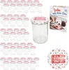 A set of glass jars with decorative lids and a recipe booklet, arranged on a white background. Podgląd zdjęcia produktu
