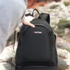 A person's hand is shown adjusting a black backpack with the 'Outtec' logo on it, set against a rocky, outdoor background. Produktbild-Vorschau