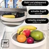 A rotating organizer tray filled with fruits and jars, placed inside a refrigerator. Produktbild-Vorschau