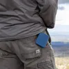 A person's back pocket with a blue silicone cutlery holder. Produktbild-Vorschau