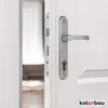 A close-up view of a silver door handle and lock mechanism on a white door. Náhľad obrázku produktu