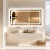 A modern bathroom with a large LED mirror, two sinks, and a basket of towels. Podgląd zdjęcia produktu