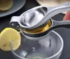 A hand is using a manual lemon squeezer to extract juice from a lemon into a glass bowl. Another lemon slice is visible on the side. Produktbild-Vorschau