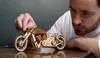 A man is looking at a wooden model motorcycle. Anteprima dell’immagine prodotto