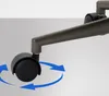 A close-up view of a black caster wheel attached to a gray metal leg of a chair, with blue arrows indicating rotation. Podgląd zdjęcia produktu