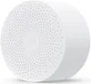 A white, round Xiaomi portable speaker with a perforated top surface and a central Xiaomi logo. Podgląd zdjęcia produktu